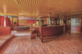 An empty and run-down bar room with a pool table and red curtains, Bad am Park, Lost Place, Essen,