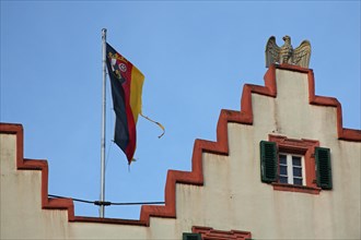 Stepped gable with flag and heraldic animal, eagle figure from the town hall, detail, house facade,