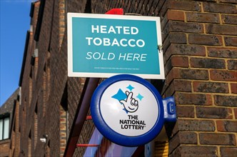 Wall signs advertising Heated Tobacco Sold here and the National Lottery, Reading, Berkshire,