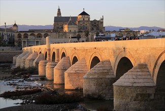 Roman bridge spanning river Rio Guadalquivir with Mezquita buildings, Cordoba, Spain, Europe