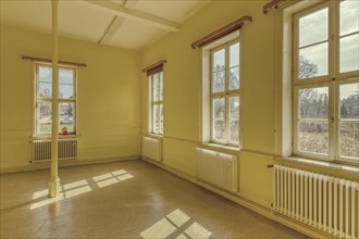 A sunlit, plain room with yellow walls and white radiators, Schachtrupp Villa, Lost Place, Osterode