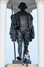 Child at the foot of a Mahatma Gandhi monument, statue, former French colony of Pondicherry or