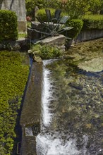 Weir with water mill wheel on a small canal in Goudargues, Departement Gard, Occitanie region,