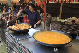 Woman cooking local food in giant pans on a market stall, Algeciras, Spain, Europe