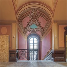 Detail of an elegant corridor with pink walls and elaborate Baroque-style ceiling paintings, Villa