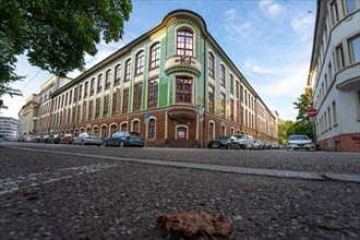 Wide-angle perspective of a historic building with green tiled facades, Kollmar & Jourdan House,