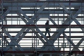 Workers on scaffolding on a riveted steel bridge during painting work in Hamburg's Hafencity,