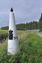White boundary, border post between the Netherlands and Belgium in polder, Meetjesland