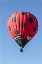 Balloonists, Aeronauts flying in hot-air balloon ressembling a giant red ladybird
