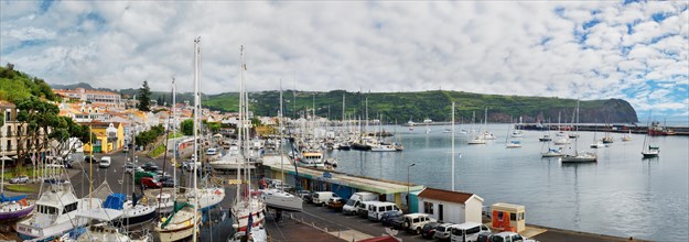 Panoramic view of a busy marina of Horta with boats and surrounded by hilly landscape, Horta, Faial
