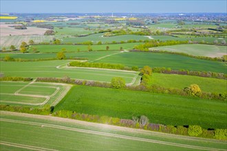 Aerial view over rural bocage landscape with fields and pastures, patchwork of plots surrounded by