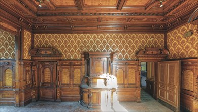 A sumptuously decorated room with wood panelling and antique furniture, Villa Woodstock, Lost