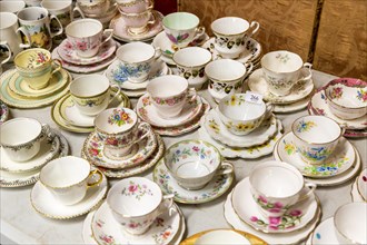 Display of antique crockery cups and saucers at auction, UK