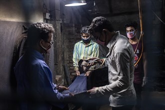Workers colouring a pair of jeans in a textile factory, Dhaka, Bangladesh, Asia