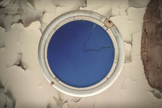 A close-up view of a round hatch window with blue eggshell texture showing cracks, Urologist's