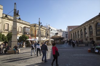 People walking in street outside historic market building, Jerez de la Frontera, Spain, Europe