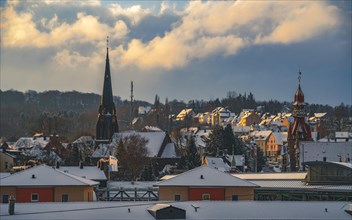 Golden sunlight over a snow-covered town with protruding church towers, Wuppertal Vohwinkel, North