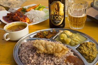 Close up of curry meal and local Lion lager beer, Mirissa, Sri Lanka, Asia