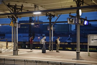 People on the platform early in the morning in front of the stainless steel plant, main railway