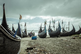 Fishing boats on the beach during a monsoon shower, Cox's Bazar, Bangladesh, Asia