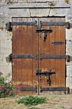 Old wooden door with heavy hinges in the citadel at Le Chateau-d'Oleron on the island Ile d'Oleron,