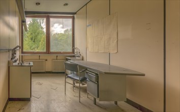 An abandoned laboratory with empty chairs and a blackboard in a dilapidated building, Biotech,