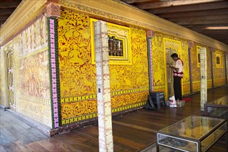 Man painting decorated wall Gangaramaya Buddhist Temple, Colombo, Sri Lanka, Asia