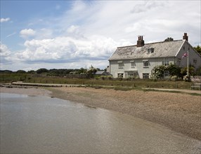 House and beach on the River Ore at Orford, Suffolk, England, UK