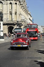 Vintage car from the 50s in the centre of Havana, open tourist bus in the back, Centro Habana,