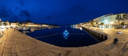 Blue hour, harbour of Mali Losinj, illuminated Christmas tree in the harbour basin, panoramic shot,