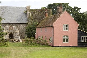 Historic pink cottage by church, Alderton, Suffolk, England, UK