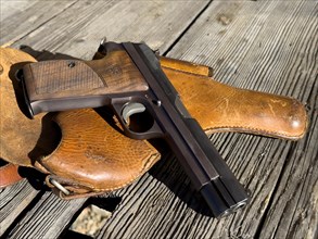 Elegant Old Handgun on an Old Wood Table with Holster in a Sunny Day, Made in Switzerland