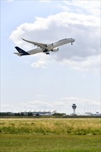 Lufthansa Airlines Airbus A350-900 taking off on Runway North with control tower, Munich Airport,