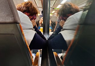View of sleeping people on a local train travelling through the night, North Rhine-Westphalia,