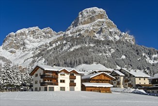The snow-covered hamlet of Colfosco, Colfosco, at the foot of the Sassongher peak, Colfosco,
