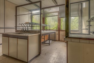 Abandoned lab bench with a view of the greenery outside through windows with blinds, Biotech,