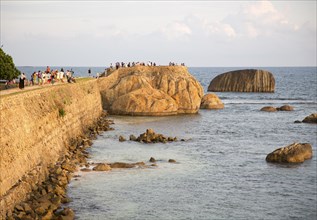 Tourists walk on fort ramparts in historic town of Galle, Sri Lanka, Asia