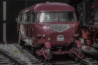 A red vintage rail bus parked on railway tracks in a museum, Dahlhausen railway depot, Lost Place,