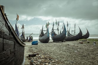 Fishing boats on the beach during a monsoon shower, Cox's Bazar, Bangladesh, Asia