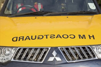 Coastguard sign with mirror writing on hood of vehicle, England, UK