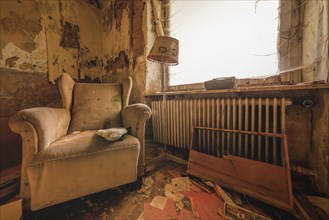 Depicting a dilapidated armchair and severe decay in a neglected room, Urologist's Villa Dr Anna L