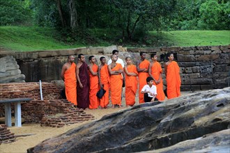 Orange robed monks, Gal Viharaya, UNESCO World Heritage Site, the ancient city of Polonnaruwa, Sri