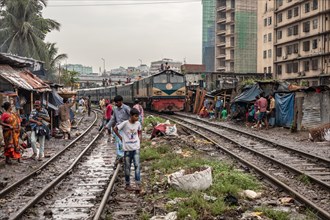 A train passes through an informal settlement built close to a railway line, Tejgaon Slum, Area,