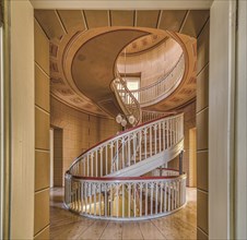 A spiral staircase in a building with a historic interior and warm lighting tones, Schachtrupp