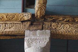 Carved wooden beam on stone pillar, Enclos Paroissial parish enclosure of Guimiliau, Finistere Penn