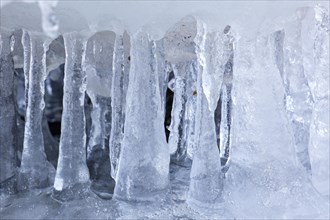 Ice formations and icicles formed by frost and freezing cold temperatures over running water of