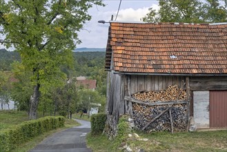 Stack of firewood piled up against wall of wooden shed in rural Croatia, Karlovac County,
