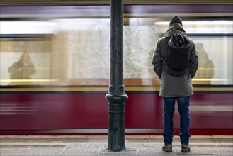 A man stands at Friedrichshagen S-Bahn station while the S-Bahn arrives. Today is the second day of