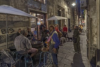 Evening scene in the old town centre with residents and a street vendor, Genoa, Italy, Europe