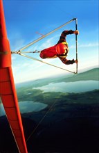 Hang glider pilot with red hangglider and red helmet in a steep curve, also called knife flight,